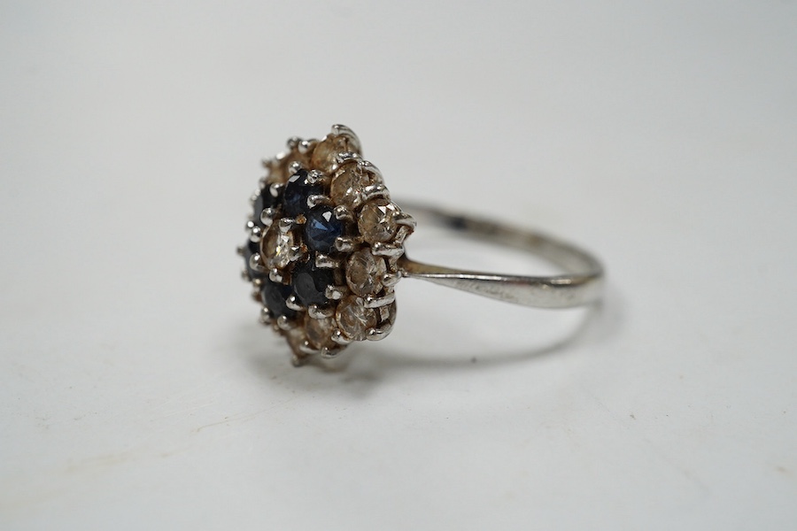 An 18ct white metal, sapphire and diamond set cluster ring, size O, gross weight 4.1 grams. Condition - fair to good